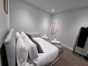 a white bedroom with a bed and a tv at Manchester St by Prestige Properties SA in Barrow in Furness