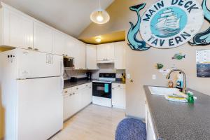 a kitchen with white cabinets and a white refrigerator at Main Deck in Pacific City