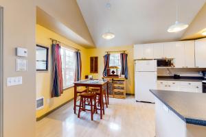 a kitchen with yellow walls and a table and chairs at Main Deck in Pacific City