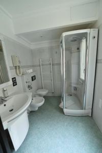 a white bathroom with two toilets and a shower at Hotel Okinawa in Rimini