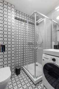 łazienka z prysznicem i pralką w obiekcie Balcia Residence w Rydze