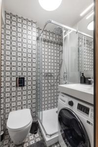 a bathroom with a washing machine and a toilet at Balcia Residence in Riga +54 photos
