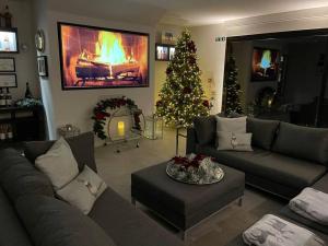 a living room with a fireplace and a christmas tree at Toppesfield Vineyard luxury, contemporary villa - 2 adults in Toppesfield