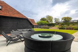 un patio con sofá, mesa y sillas en Toppesfield Vineyard luxury, contemporary villa - 2 adults, en Toppesfield