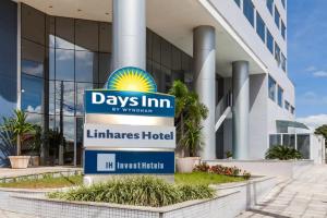 una señal frente a un edificio en Days Inn by Wyndham Linhares en Linhares