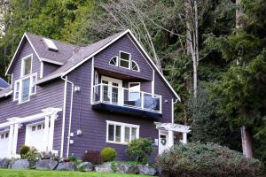 Casa morada con puerta blanca y ventanas en Sea and Cedar Retreat-a home in a tranquil setting en Cowichan Bay