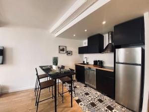 kuchnia ze stołem i lodówką ze stali nierdzewnej w obiekcie Appartement Centre ville, Cannes le Suquet w Cannes