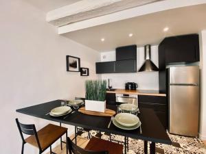 kuchnia z czarnym stołem i lodówką ze stali nierdzewnej w obiekcie Appartement Centre ville, Cannes le Suquet w Cannes