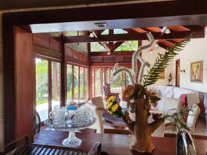 a dining room with a table with a vase of flowers at Casa de campo em Bananeiras Cond.Águas da Serra in Bananeiras