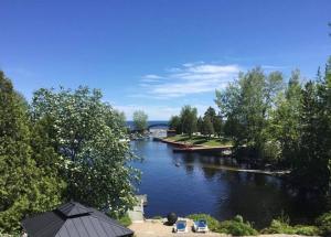 a view of a river with trees and a bridge at Le Cocon du Rivage in Roberval