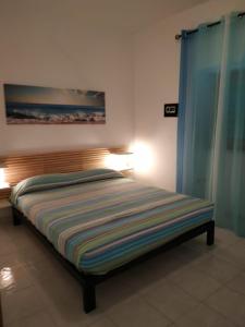 1 dormitorio con 1 cama con una pintura en la pared en Villa Mirabilis, en Vieste