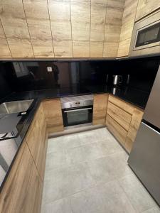 a kitchen with wooden cabinets and a stove at Duplex en centro de calella in Calella