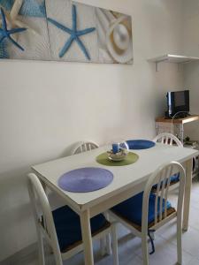 una mesa blanca con sillas y un plato en ella en Villa Mirabilis, en Vieste