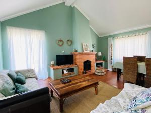 uma sala de estar com um sofá e uma lareira em A Quinta da Estrelinha em Quinta de Cavaleiros