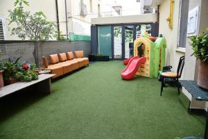 ein Wohnzimmer mit Spielplatz und Sofa in der Unterkunft Hotel Okinawa in Rimini