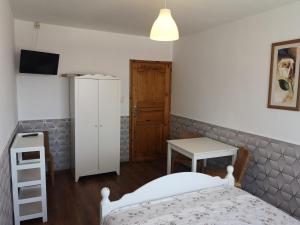 a bedroom with a bed and a table and a cabinet at Pokoje gościnne Bartek in Białogóra +22 photos