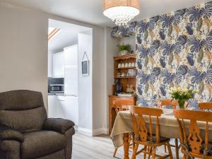 a kitchen and dining room with a table and a chair at Cwmcarn Cottage in Crosskeys