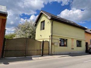 une maison jaune avec une clôture devant elle dans l'établissement casa Ecaterina, à Turda