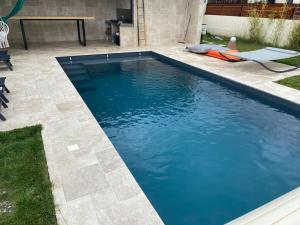 una piscina de agua azul en un patio en Maison spacieuse, quartier calme, piscine chauffe, en Cenon