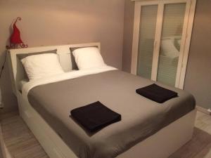 1 dormitorio con 1 cama con 2 toallas en Maison spacieuse, quartier calme, piscine chauffe, en Cenon