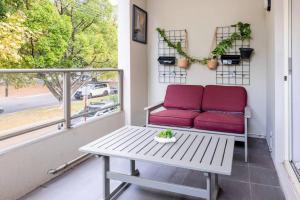 a red couch on a porch with a window at Modern Town house - Close to CBD in Perth