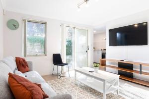 a living room with a couch and a tv at Modern Town house - Close to CBD in Perth
