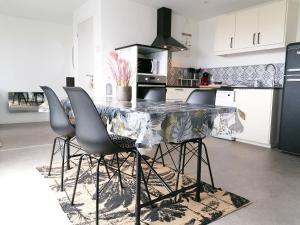 - une cuisine avec une table et des chaises en marbre dans l'établissement le Ti'Nid - Gîte de charme - Vue Mer, à Langueux