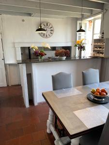 a dining room with a table and a kitchen at Maison gasconne in Castillon-Debats