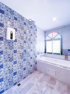 a bathroom with a tub and a window at La Reina Maroc Hotel ปากช่อง เขาใหญ่ in Pak Chong