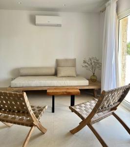 een woonkamer met een bank en 2 stoelen bij Serena Sol in Cala Serena