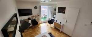 a living room with a television and a table and chairs at PLEIN SUD Terrasse Panoramique Climatisation Garage Netflix in Lyon