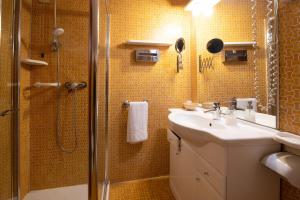 bagno con doccia, lavandino e specchio di Residence La Fenice a Padova
