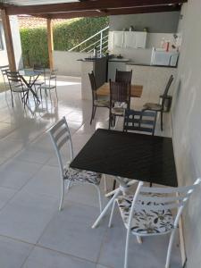a table and chairs in a patio with a kitchen at Hospedagem Casa Branca Localizada em um bairro nobre de Capitólio, Escarpas do Lago in Capitólio