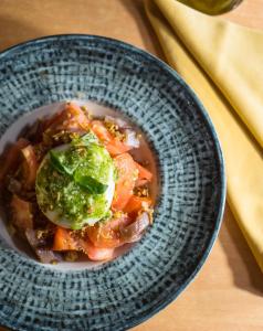 a blue bowl of food with tomatoes and pesto at Hotel Jaqués in Jaca