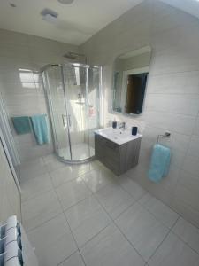 a white bathroom with a shower and a sink at Castle View Rooms in Liscannor