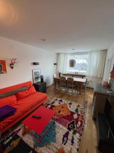 a living room with a red couch and a table at Art & View - Apartment in Bad Gastein