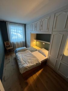 a bedroom with two beds and white cabinets at Art & View - Apartment in Bad Gastein