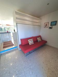 a red couch in a room with a window at SEA SIDE in Mandelieu-La Napoule