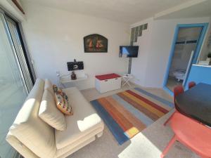 ein Wohnzimmer mit einem weißen Sofa und einem Tisch in der Unterkunft SEA SIDE in Mandelieu-la-Napoule