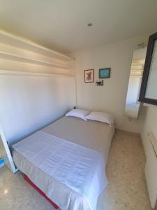 ein kleines Schlafzimmer mit einem Bett und zwei Fenstern in der Unterkunft SEA SIDE in Mandelieu-la-Napoule