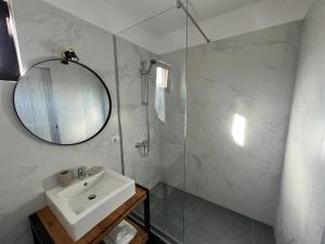 W białej łazience znajduje się umywalka i lustro. w obiekcie Vily Luxury Rooms w mieście Fokszany