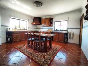 a kitchen with a table and chairs on a rug at Villa Intuitiva in Lourinhã