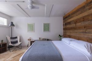 Schlafzimmer mit einem großen Bett mit einem Kopfteil aus Holz in der Unterkunft The Graham & Co. in Phoenicia