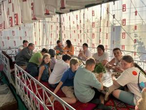 um grupo de pessoas sentadas à volta de uma mesa em Guest house "NIKA", Nukus em Nukus