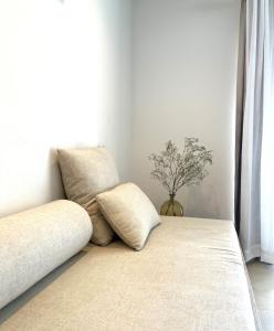 a couch with two pillows in a room with a window at Serena Sol in Cala Serena