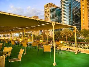 a group of tables and chairs on a balcony with buildings at Prince Omar Boat in Cairo