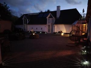 a house with lights in a courtyard at night at Trandafir Guesthouse in Egtved