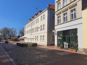 a cobblestone street in front of a white building at Apartament Tuchola in Tuchola