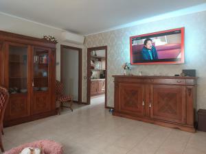 uma sala de estar com televisão na parede em Stanza Singola - Certosa em Milão