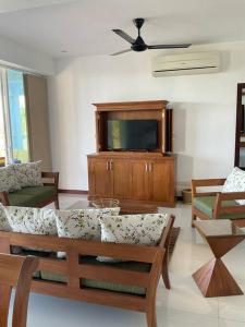 a living room with a table and a tv at Sandy Shores in Trincomalee